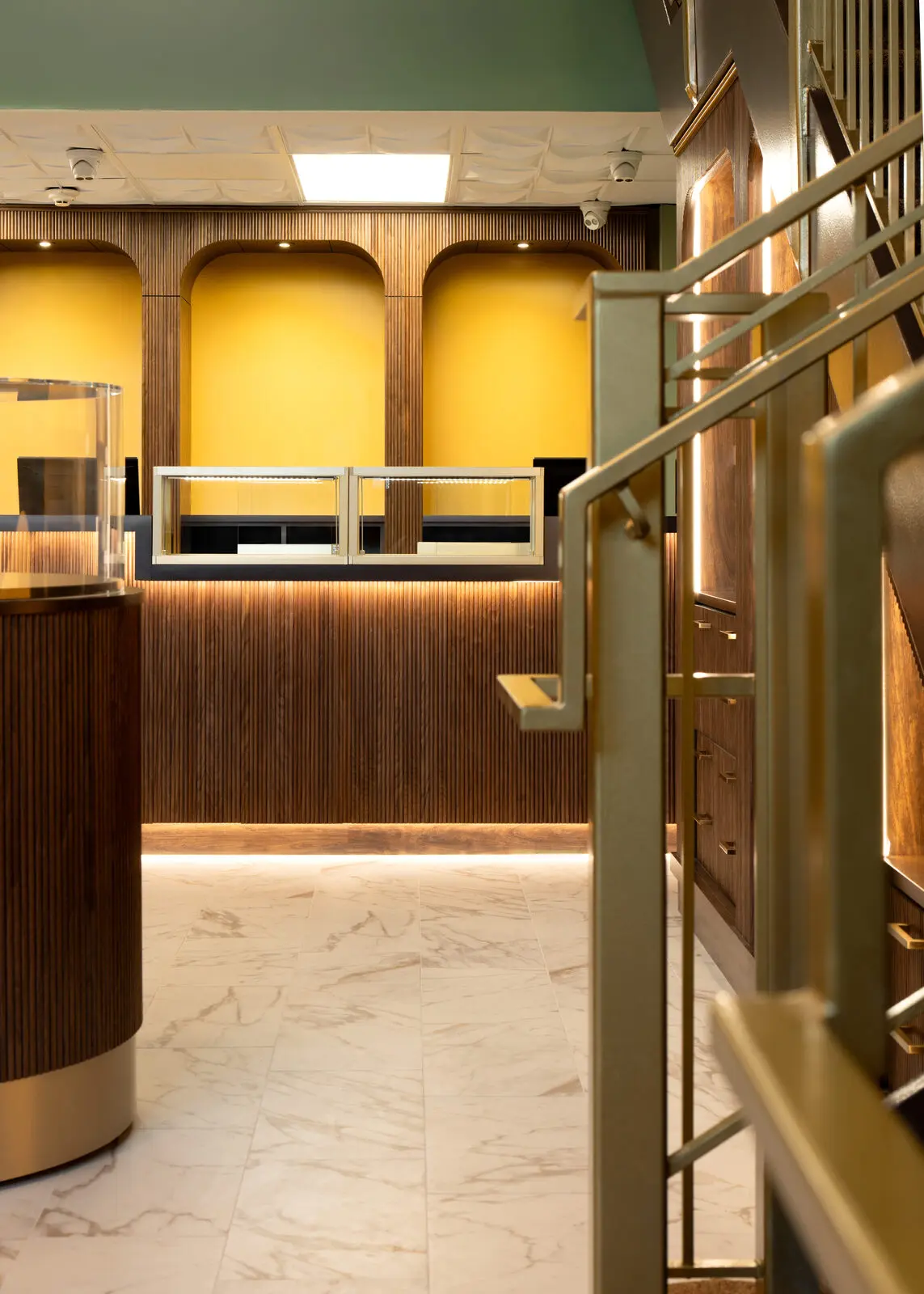 Two-story interior with grand staircase and gold-lit display arches
